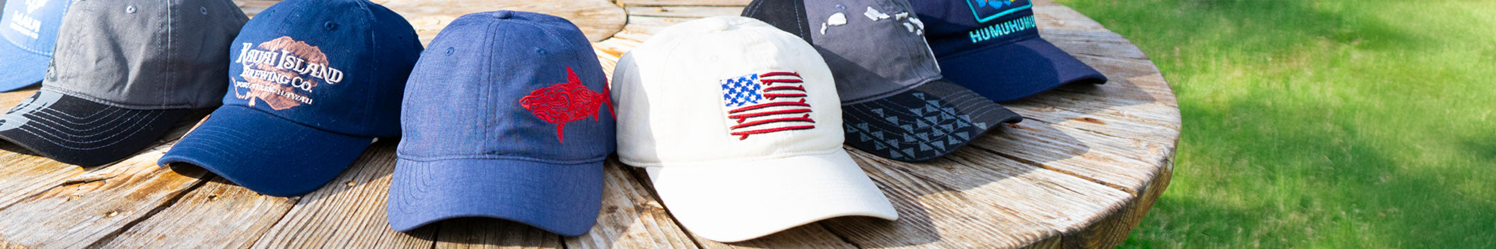 Collection of baseball caps with various designs on a wooden surface.