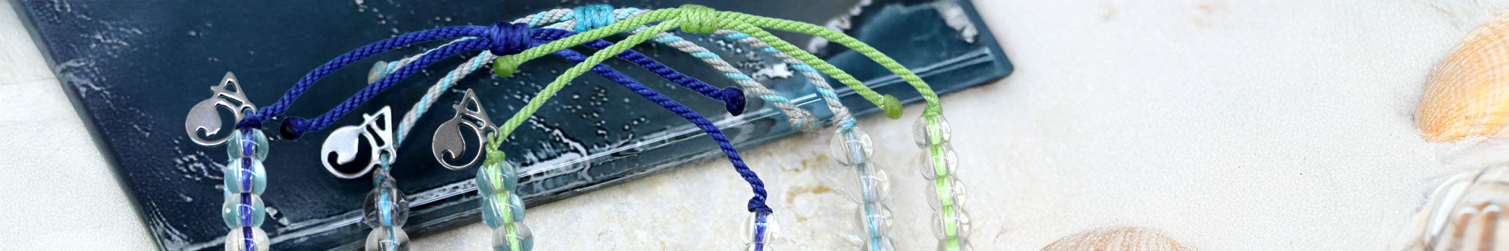 Close up of 4Ocean Bracelets on a sandy background