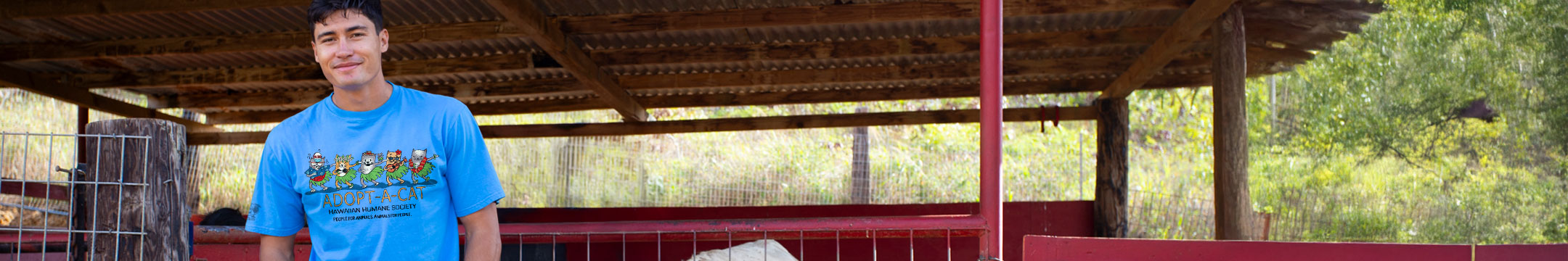 Person wearing a blue t-shirt with text in an outdoor setting