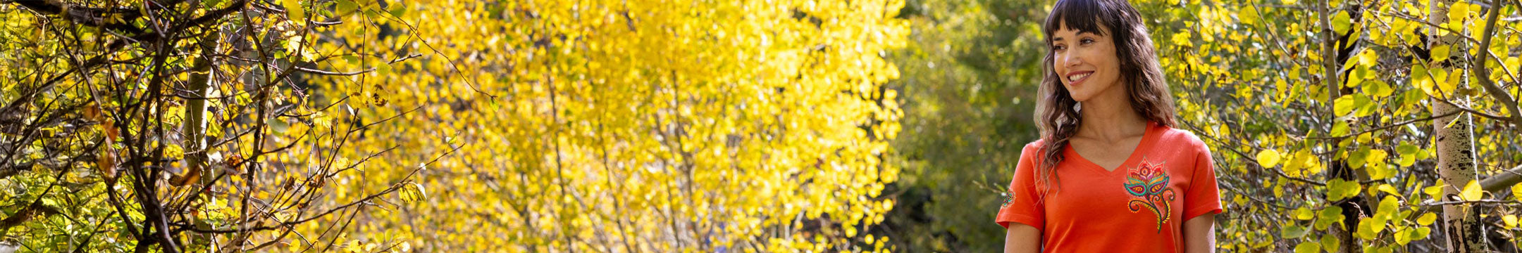 Woman standing in a forest with yellow leaves