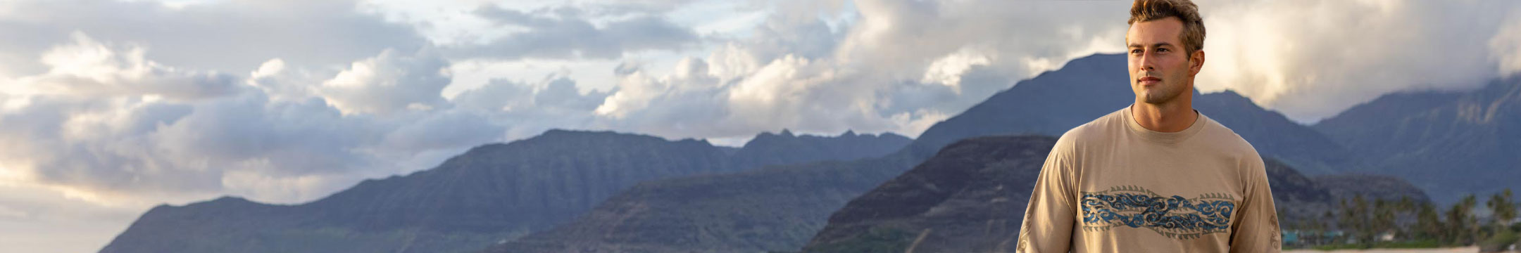 Man standing in front of a mountain range with clouds