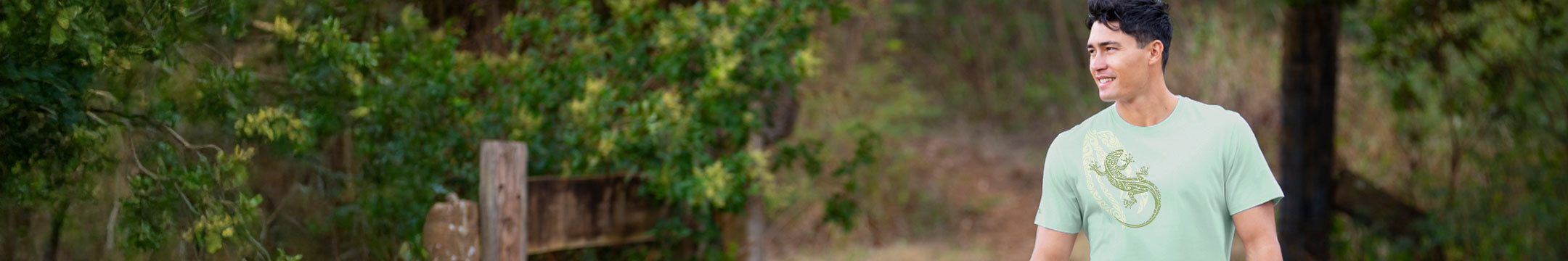 man standing in the forest wearing a green shirt