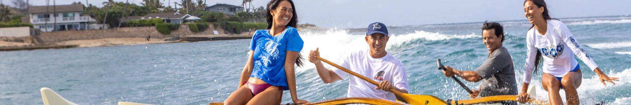 group of people in a canoe on the ocean smiling and laughing.