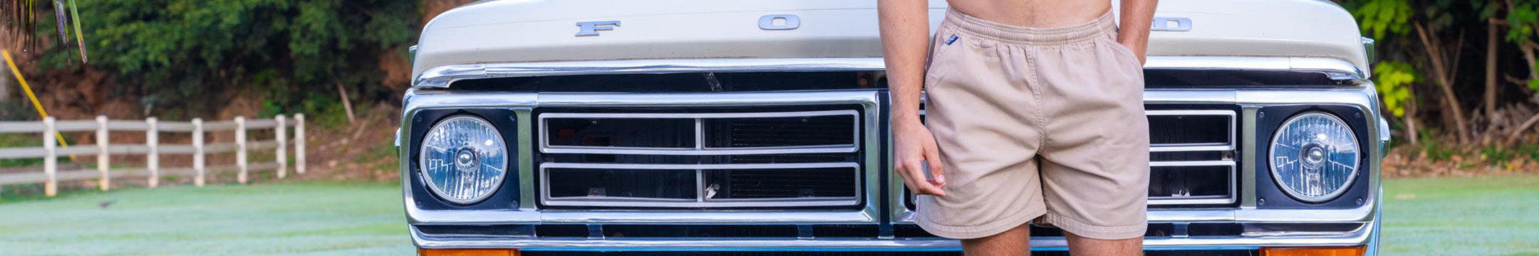 Person standing in front of a vintage truck on a sports field