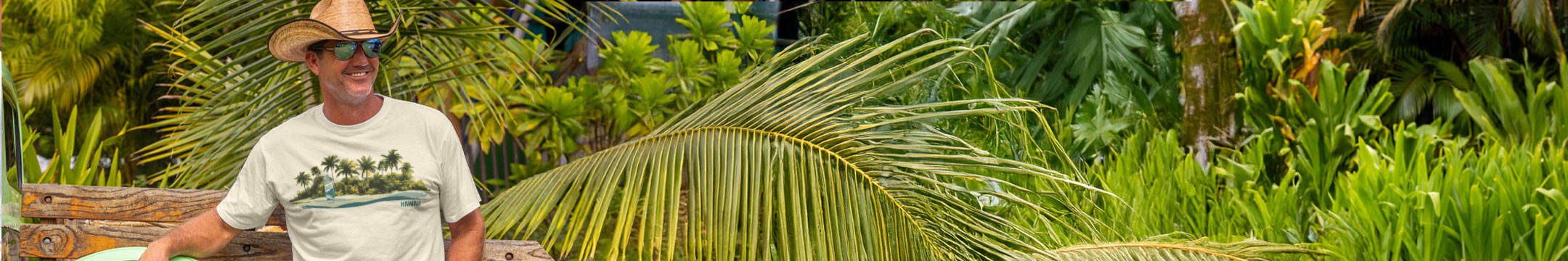 Man standing in a tropical setting with palm leaves and greenery wearing a coconut dyed Crazy Shirt Tee