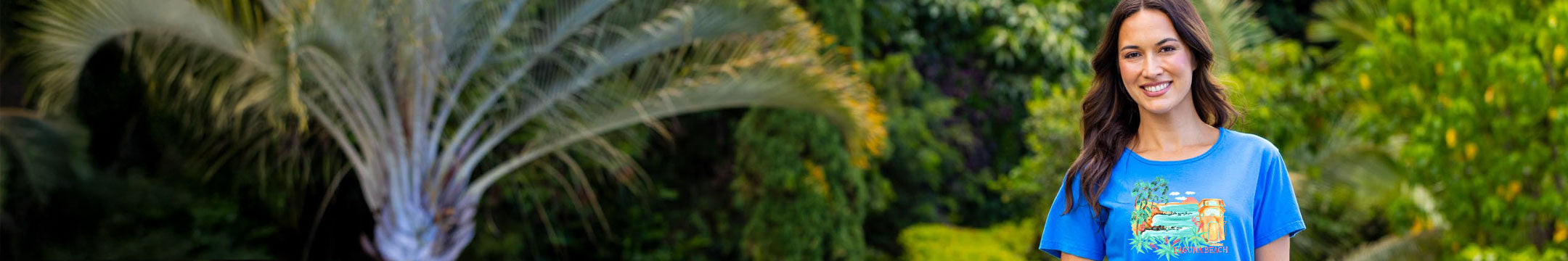 Woman in a blue shirt standing in a garden with greenery