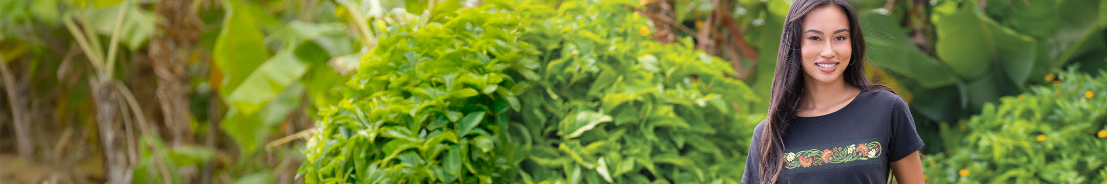 Woman standing in a lush green garden wearing a Crazy Shirt Tee