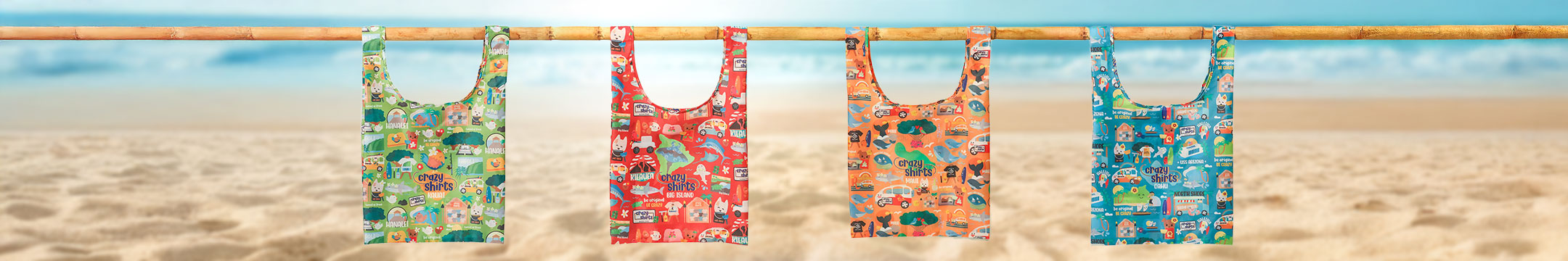 Four colorful reusable shopping bags hanging on a wooden rod against a beach background