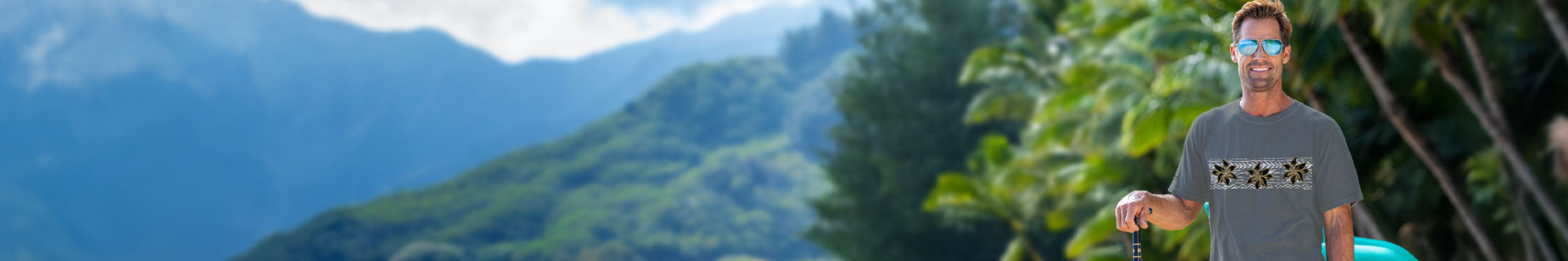 Person standing outdoors with mountains and trees in the background