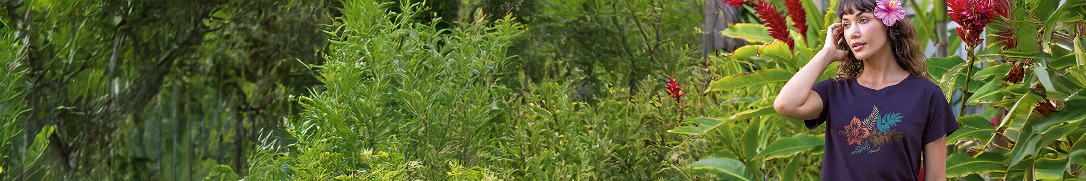 Person standing in a lush green garden with flowers
