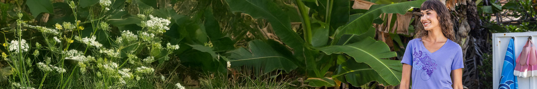 Woman standing next to a large plant with a scenic background
