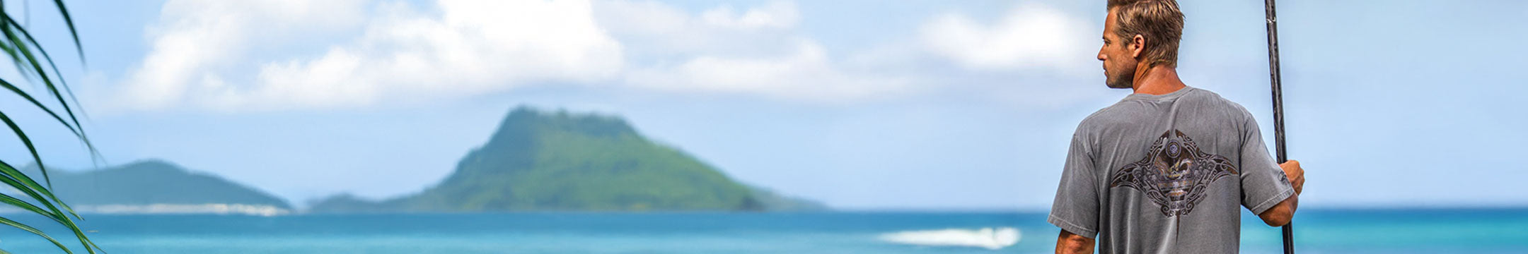 Man holding a fishing rod with a tropical island in the background