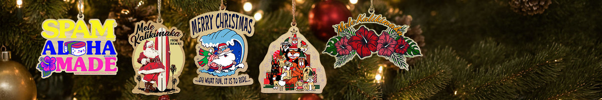 Four colorful Christmas ornaments hanging on a Christmas tree with warm lights and green pine branches in the background. The ornaments feature festive designs including a 'SPAM ALOHA MADE' sign, a Santa Claus ornament, a blue snowman ornament, and a 'Merry Christmas' ornament.