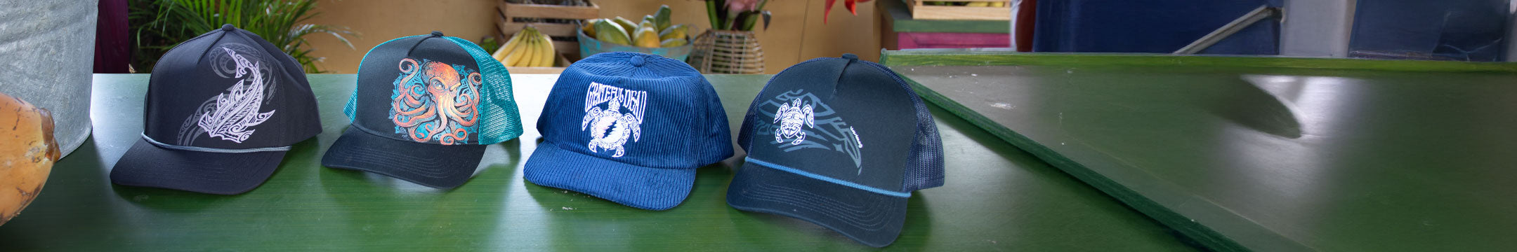 Five baseball caps with different designs on a green surface