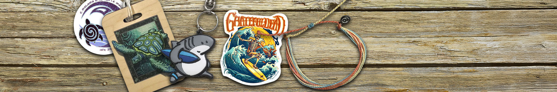 Collection of stickers and a keychain on a wooden surface