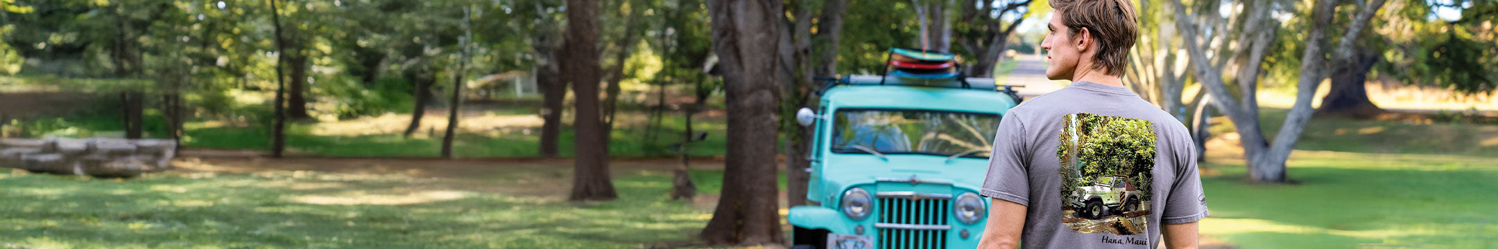 Man wearing a Jeep t-shirt with a scenic print in a park setting