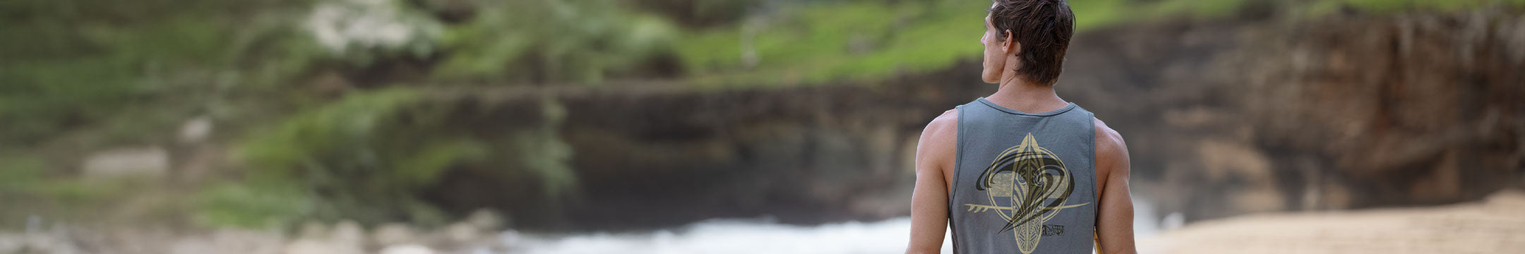 Man walking on the beach wearing a tank top with a Big Island design