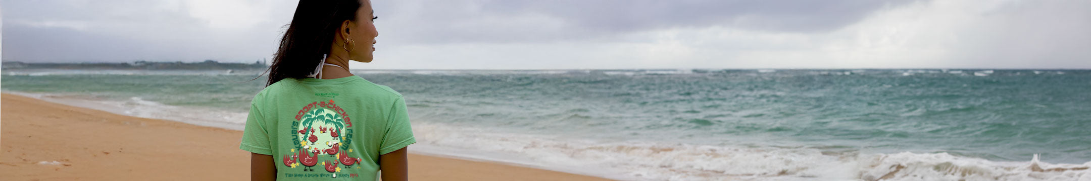 Woman wearing a Key lime Dyed Kauai t-shirt with a graphic design on a beach