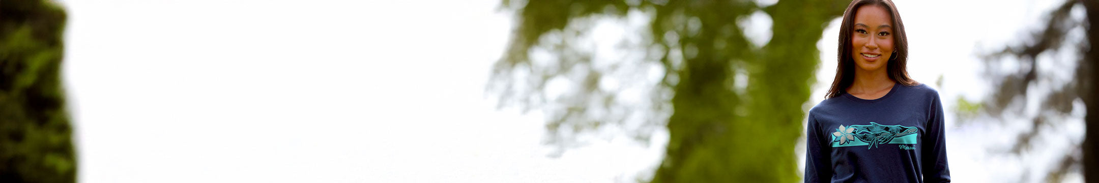 Person wearing a dark blue shirt with a graphic design outdoors