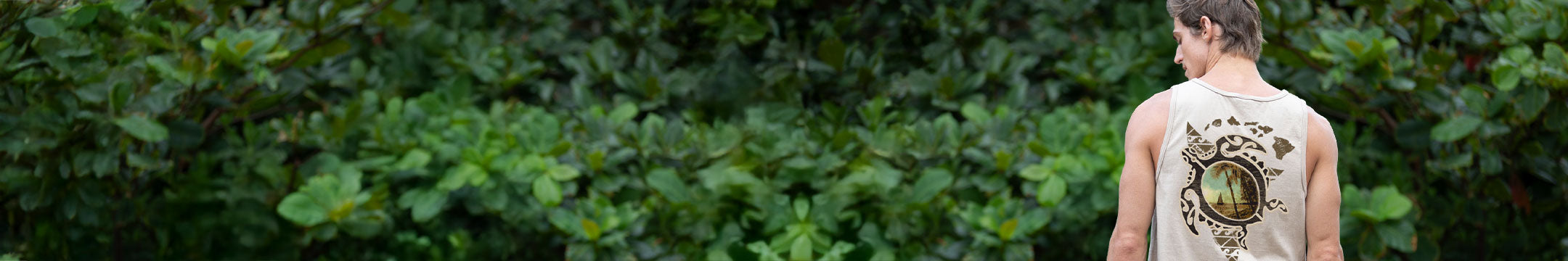 Person standing in a forest with a sleeveless shirt featuring a turtle graphic design.