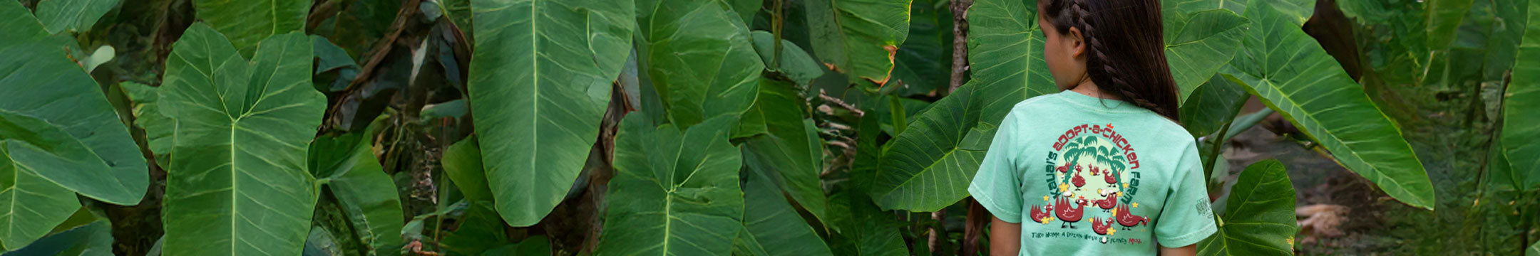 A kid wearing a crazy shirt design standing in front of a jungle