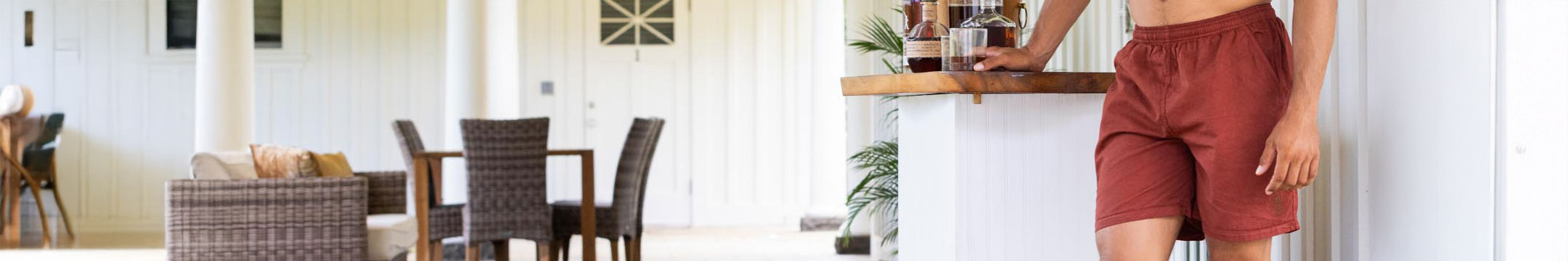 Person whiskey dyed red shorts standing in a modern kitchen.