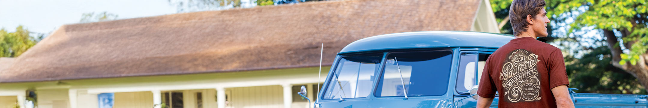 Person standing next to a blue van in front of a house