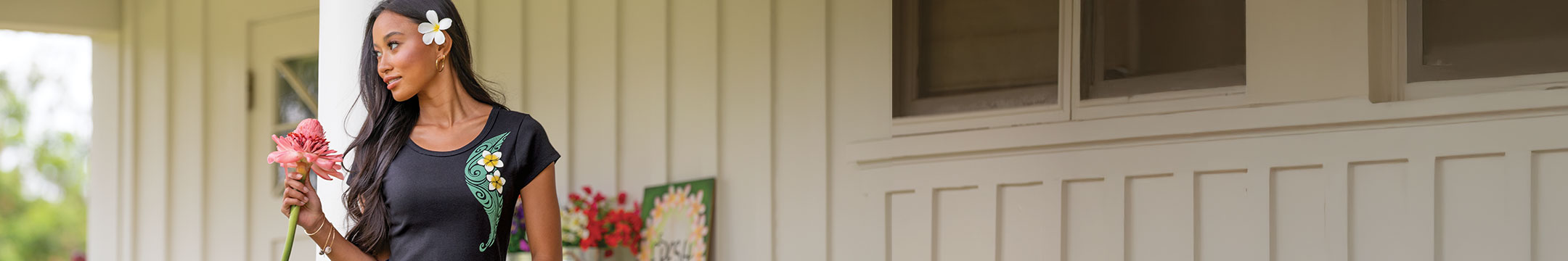 Woman holding flowers in front of a building with a blurred background