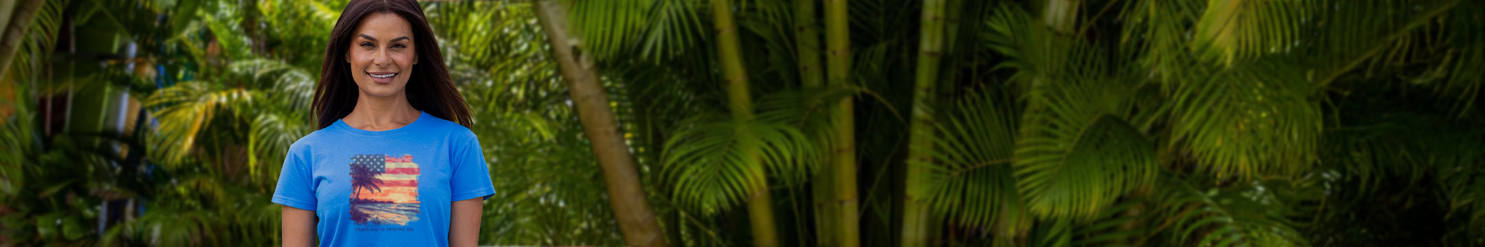 Woman in a blue t-shirt standing among tropical plants