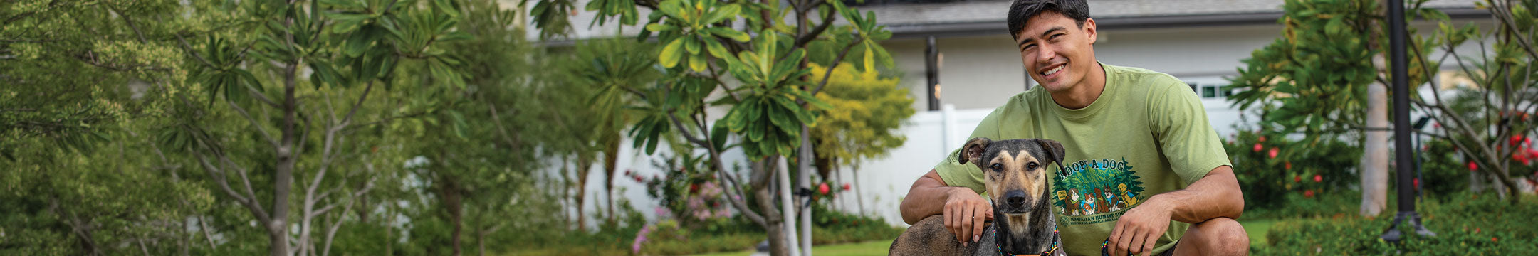 Man sitting on grass with a dog in a garden setting
