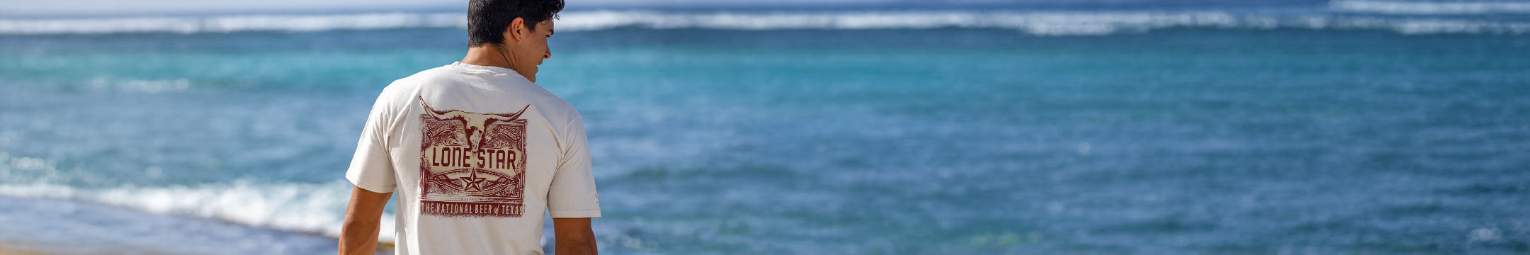Man standing on a beach looking at the ocean
