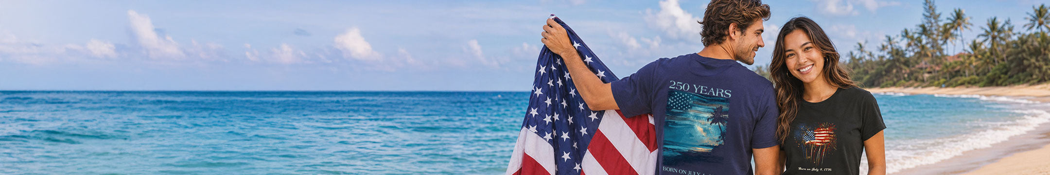 Two people on a beach holding an American flag and a surfboard with ocean and sky in the background
