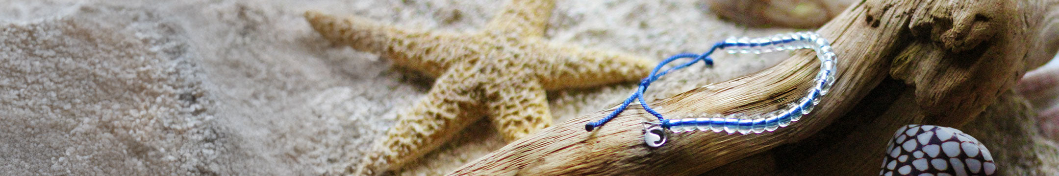 Starfish and bracelet on a sandy surface