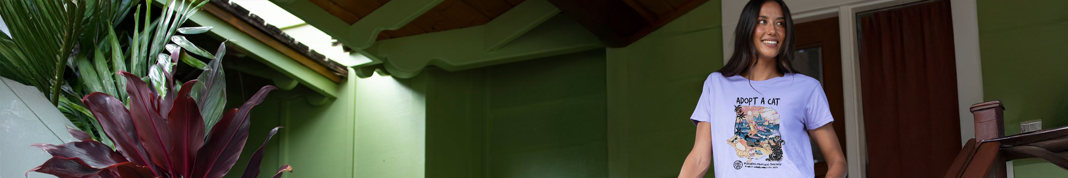 Woman standing in front of a green building with plants