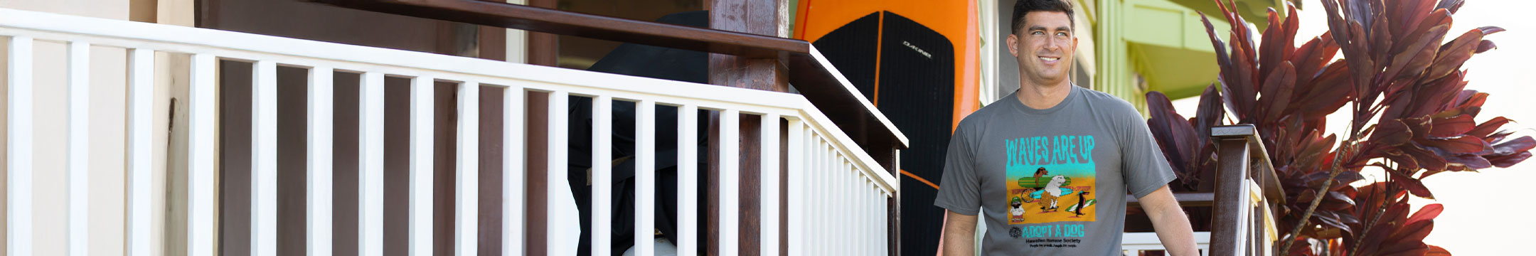 Man wearing a t-shirt with a graphic design standing on a porch.