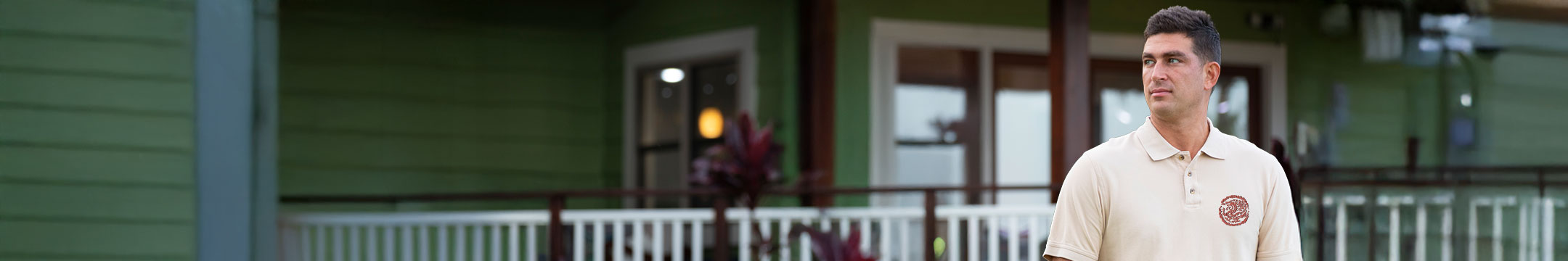 Man standing in front of a house with a green exterior