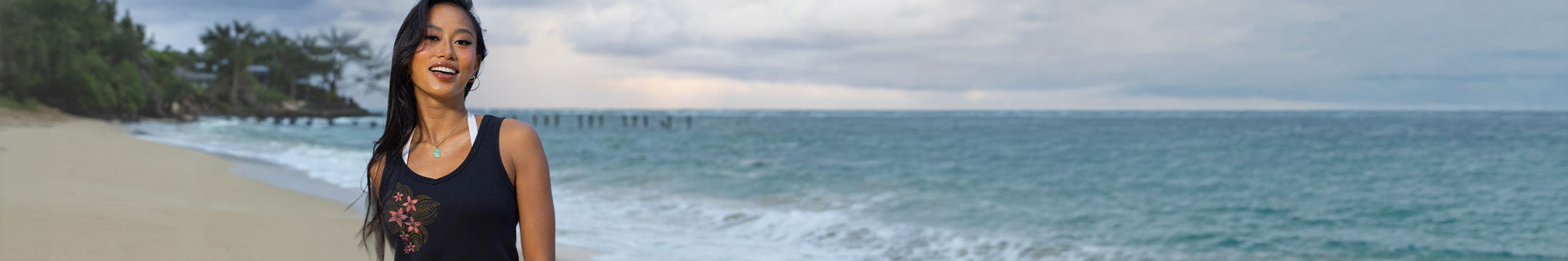Woman standing on a beach with ocean and sky in the background