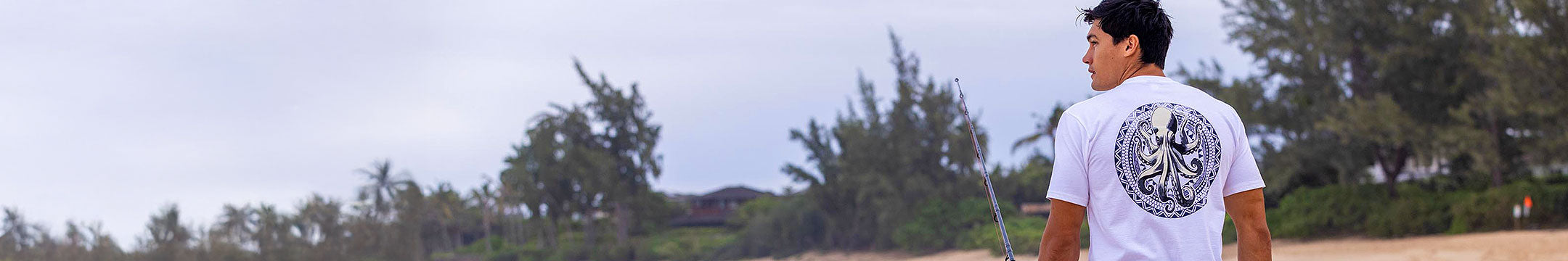 Person standing on a beach with trees in the background