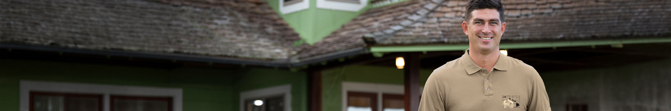 Man standing in front of a green building with a brown roof