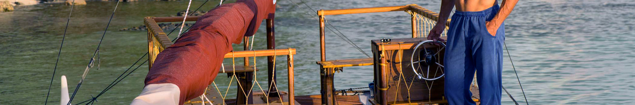 Person standing on a boat wearing blue pants