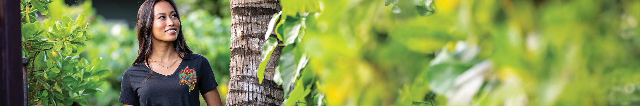 Woman standing among tropical plants with a blurred background