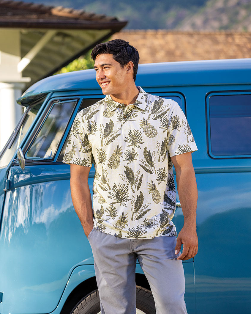 Man wearing a tropical polo standing in front of a blue van