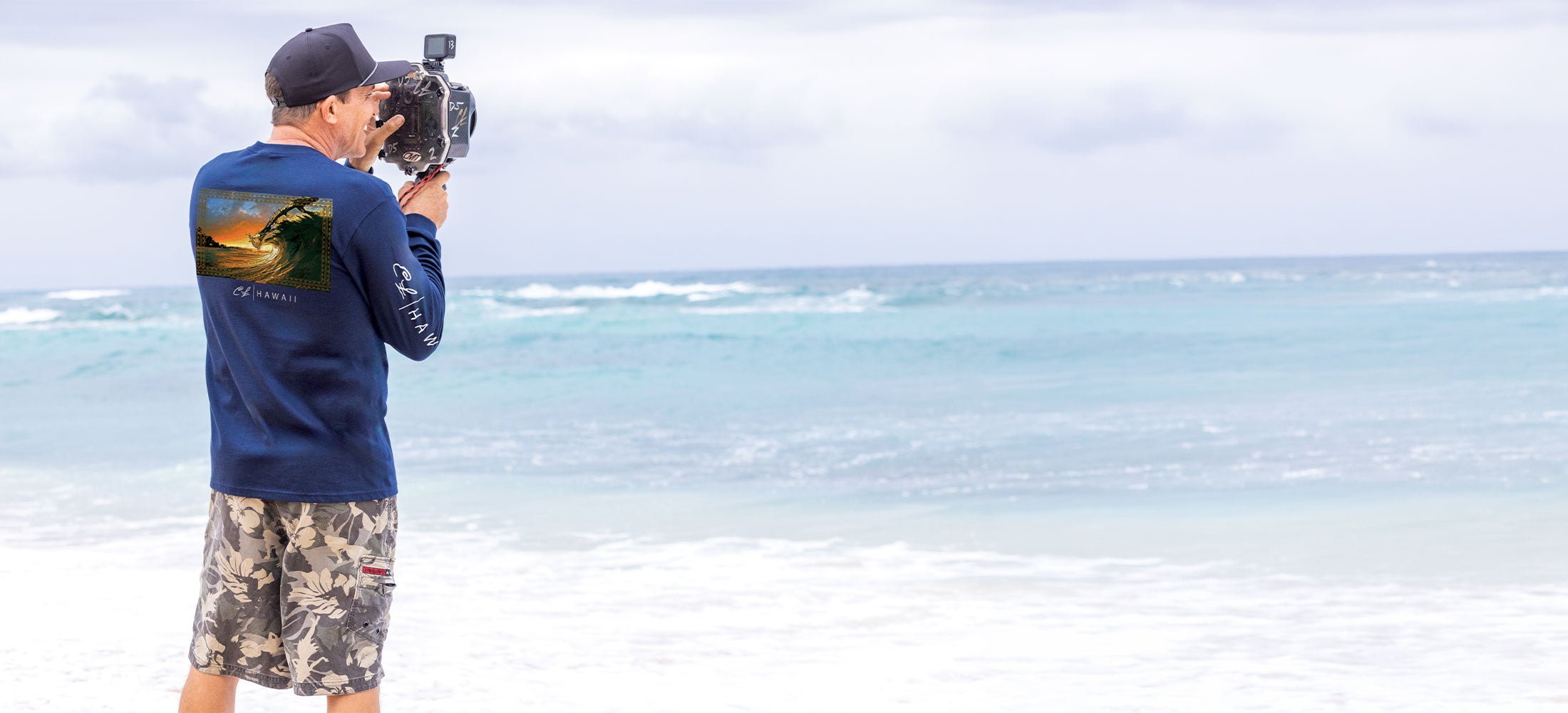 Person filming on a beach with ocean view