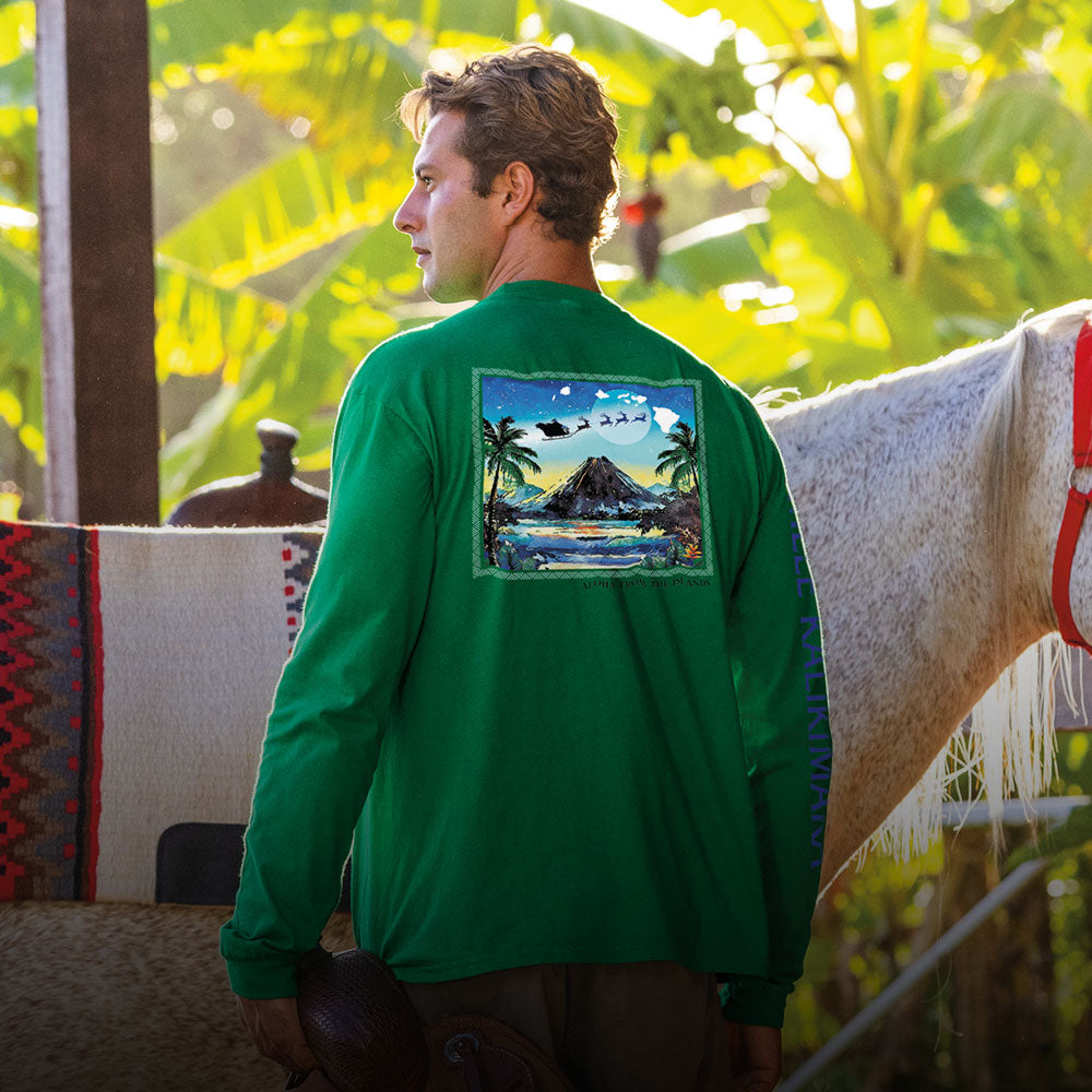 Man wearing a green shirt with a graphic design standing next to a horse in a natural setting.