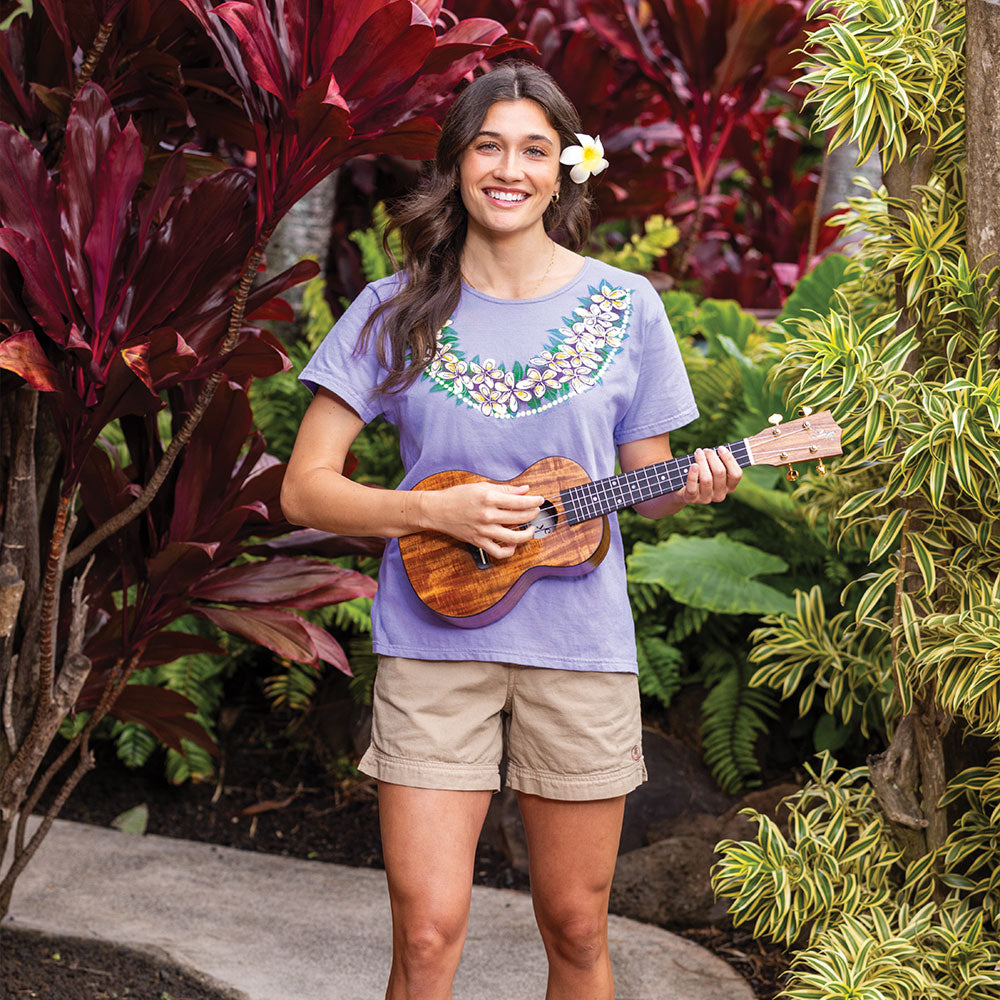 Woman playing a ukulele in a garden setting