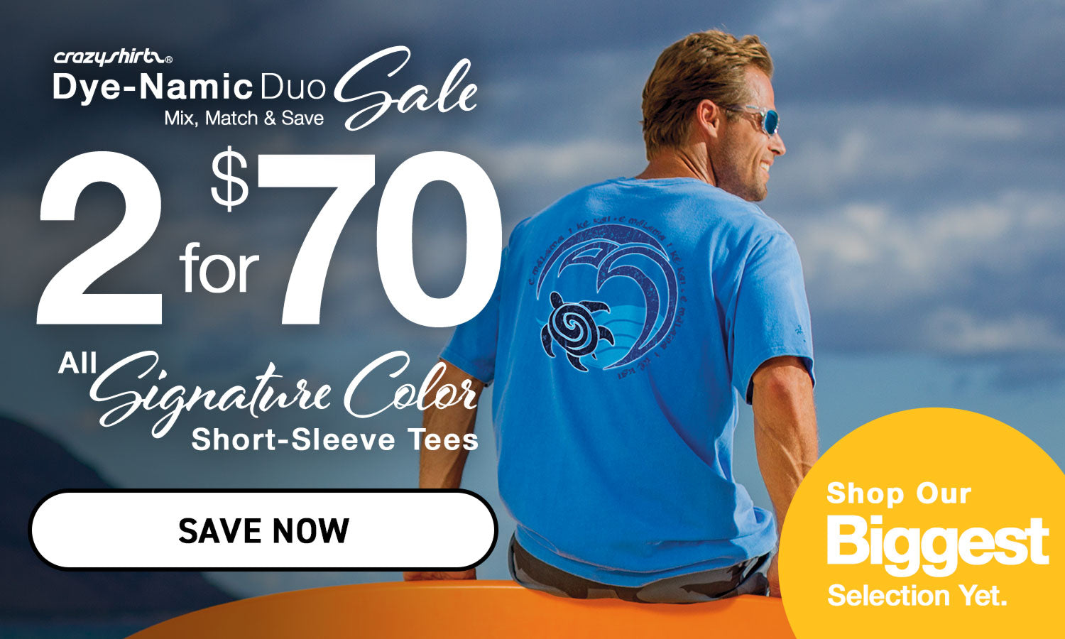 Man wearing a blue t-shirt with a turtle design, sitting on a rock with a scenic background, promoting a Dye-Namic Duo Sale.
