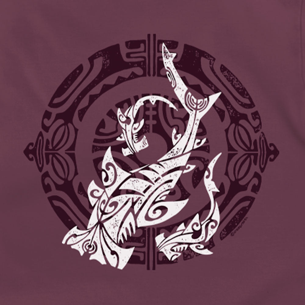 A close-up of a maroon or burgundy fabric surface featuring a large white and dark maroon graphic print with stylized curved abstract forms and ornamental circular details.