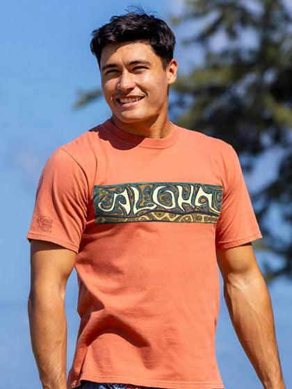 Man wearing a Chili Dyed t-shirt with 'Aloha' design outdoors
