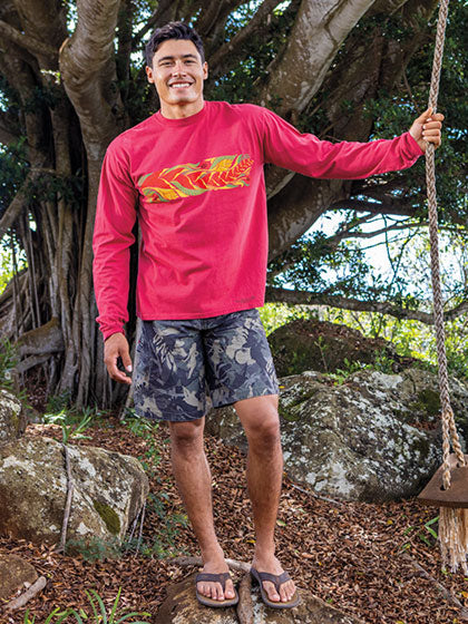 Man wearing a red long-sleeve Crazy Shirt with a logo in a natural setting