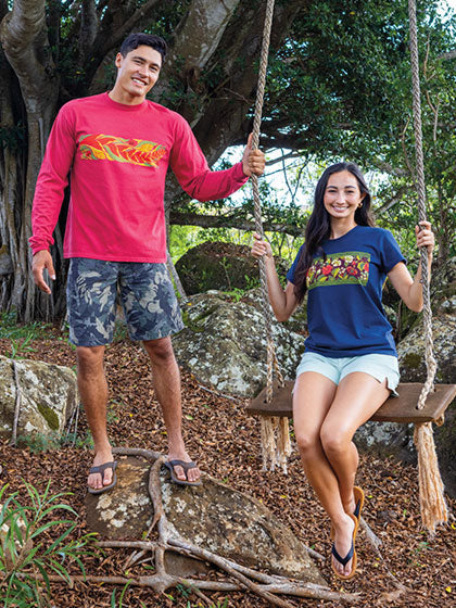 Two people wearing Crazy Shirt floral designs outdoors, one on a swing.